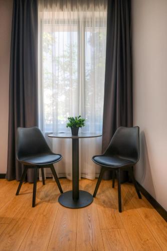 two chairs and a table in front of a window at Smart Rooms in Varna City
