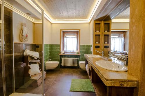 een badkamer met een wastafel, een bad en een toilet bij B&B Rossodisera in Domegge di Cadore