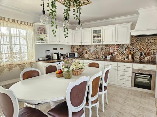 a kitchen with a white table and chairs at Sunshine, casa de campo e praia, estilo e conforto, espaço e privacidade, perfeita para as suas férias em Olhão in Moncarapacho