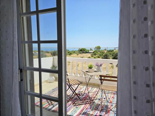 a view from a window of a balcony with a table at Sunshine, casa de campo e praia, estilo e conforto, espaço e privacidade, perfeita para as suas férias em Olhão in Moncarapacho