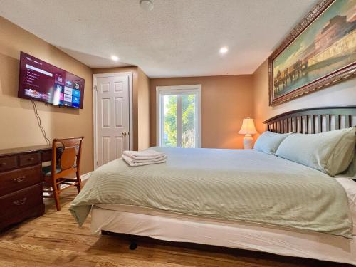a bedroom with a large bed and a tv at Cozy Home Near Transit & Hillcrest Mall with Free Parking in Richmond Hill