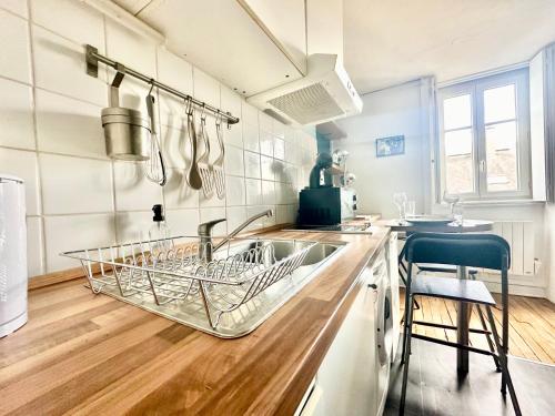 - une cuisine avec un évier doté d'un étendoir à vaisselle dans l'établissement Le Beaupeyrat, chaleureux et calme, à Limoges