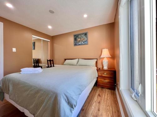 a bedroom with a large bed and a window at Cozy Home Near Transit & Hillcrest Mall with Free Parking in Richmond Hill