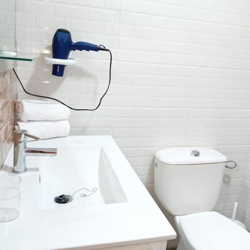 a white bathroom with a sink and a toilet at APAR MARI 2c in Las Lagunas
