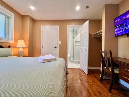 a bedroom with a bed and a flat screen tv at Cozy Home Near Transit & Hillcrest Mall with Free Parking in Richmond Hill