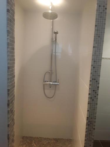 La salle de bains est pourvue d'une douche et d'un mur blanc. dans l'établissement Chambre d'hôte équipée avec terrasse verdoyante, à Saint-Rémy-de-Provence