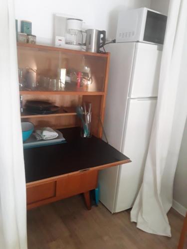 - une cuisine avec une petite table à côté d'un réfrigérateur dans l'établissement Chambre d'hôte équipée avec terrasse verdoyante, à Saint-Rémy-de-Provence