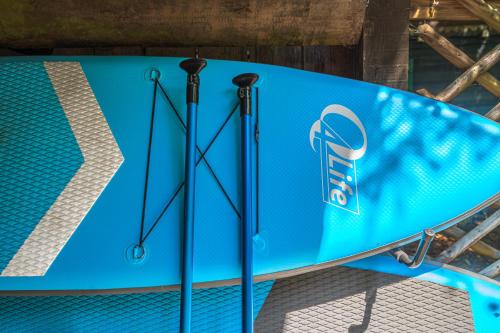 une planche de surf bleue exposée sur un support dans l'établissement Le Petit Rêve - Lac de Montriond, à Montriond