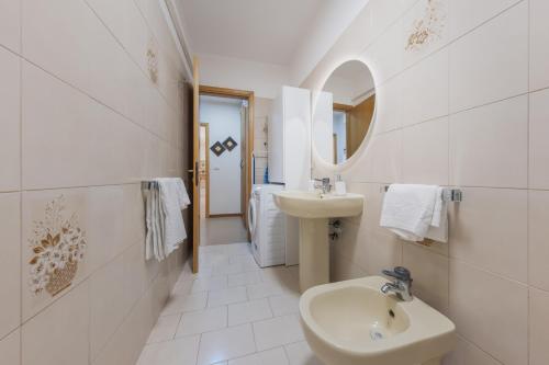 a white bathroom with a sink and a mirror at Art & Culture Biennale - Venezia Sweet Stay in Venice
