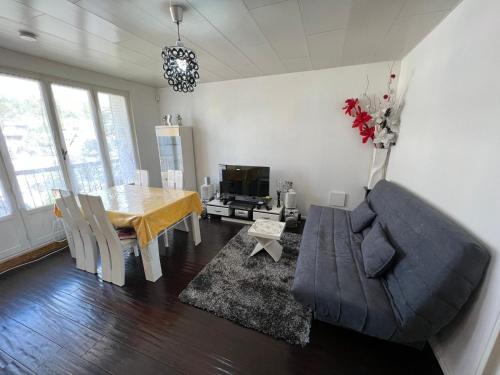 un salon avec une table et un canapé dans l'établissement Bel appartement familial 6 personnes avec balcon, à Noisy-le-Sec