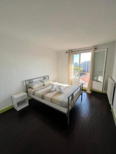 une chambre avec un lit et une grande fenêtre dans l'établissement Bel appartement familial 6 personnes avec balcon, à Noisy-le-Sec
