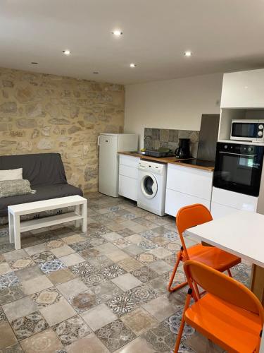 un salon avec un canapé et une cuisine dans l'établissement Appartement au calme proche centre, à Alès