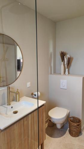une salle de bain avec un lavabo, des toilettes et un miroir dans l'établissement L'appart Lila - Jacuzzi vue mer, à Lacanau