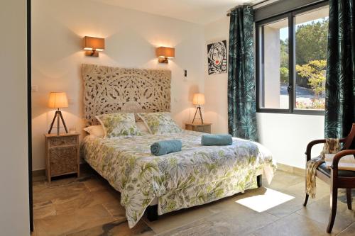 a bedroom with a bed and a large window at Résidence Capicciolo Villa A CIGALA in Olmeto