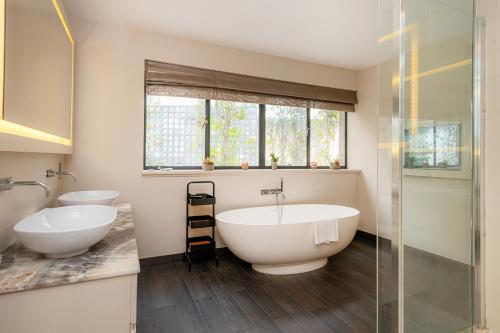 a bathroom with two sinks and a bath tub at Luxury 3BR Home in Belgravia, Near Victoria in London