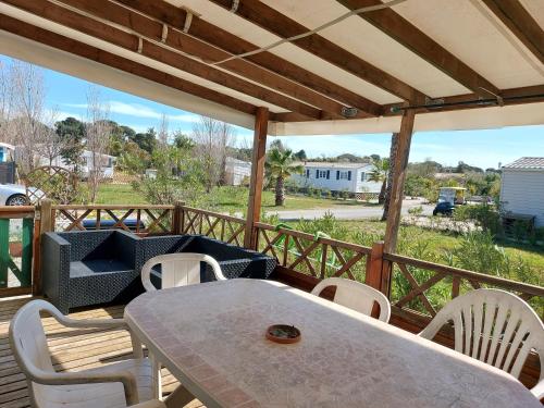 un patio avec une table et des chaises sur une terrasse dans l'établissement Familial, à Hyères