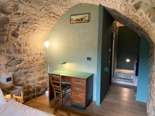 a bedroom with a desk in a stone wall at La Casa Medievale Suites e SPA in Pontremoli