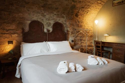 a bedroom with a bed with towels on it at La Casa Medievale Suites e SPA in Pontremoli