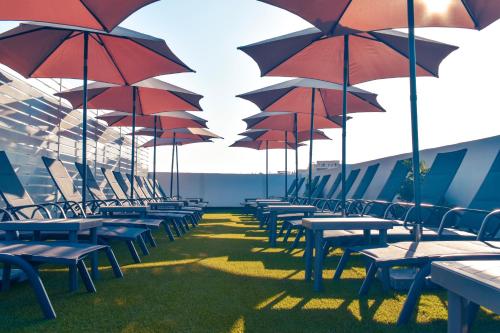 a row of tables and chairs with umbrellas at 101 Moroni by Cast Renting in Il-Gżira