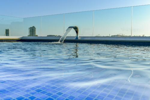 a swimming pool with a water hose in the water at 101 Moroni by Cast Renting in Il-Gżira