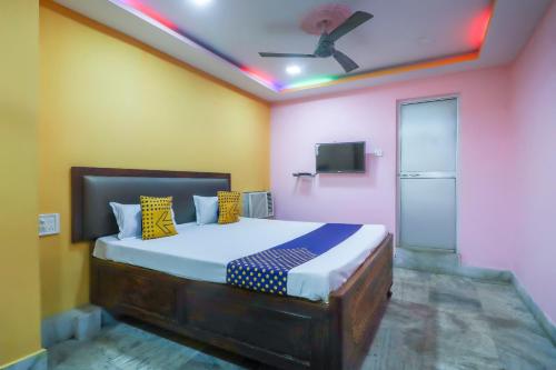a bedroom with a bed with yellow and pink walls at Hotel O Bright in Jamshedpur