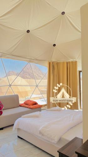 a bedroom with a tent with a bed and a couch at RUM WORLD BUBBLE lUXURY CAMP in Wadi Rum
