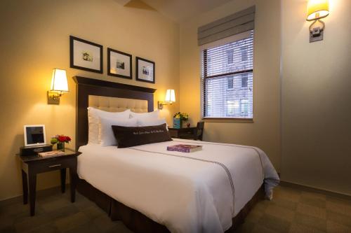 a bedroom with a large white bed and a window at Library Hotel by Library Hotel Collection in New York