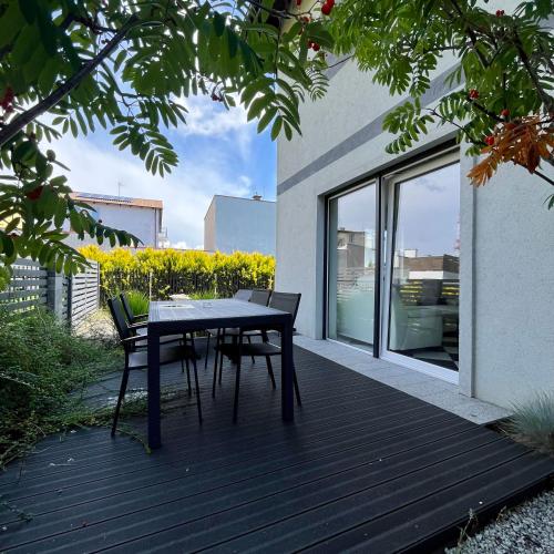a wooden deck with a table and chairs on a house at Apartamenty Na Fali in Kołobrzeg