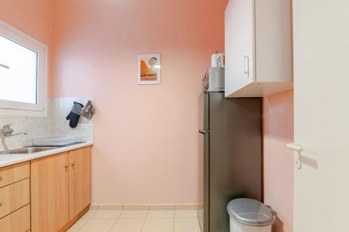 a kitchen with a refrigerator and a sink at Seaside Escape Apartments - Poseidon in Palaia Fokaia