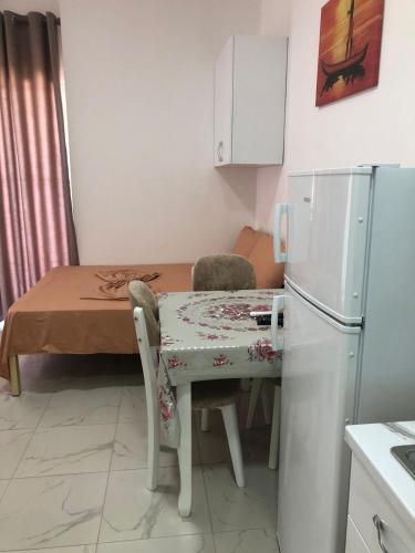 a small kitchen with a table and a refrigerator at Guesthouse Xhuli in Shëngjin