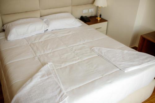 a white bed with white sheets and pillows at Pyramids Sunshine View in Cairo