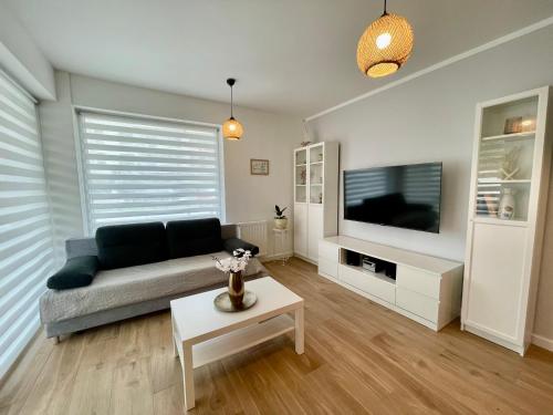 a living room with a couch and a tv at Oaza Przystań in Giżycko