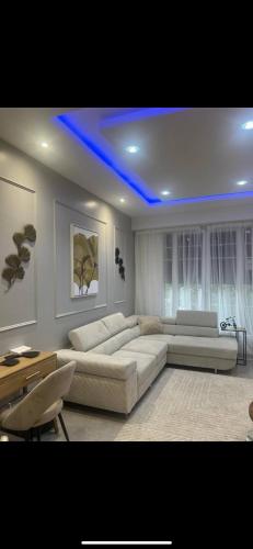 un salon avec un canapé et un plafond bleu dans l'établissement 3 Pièces de Haut Standing Nice, à Nice