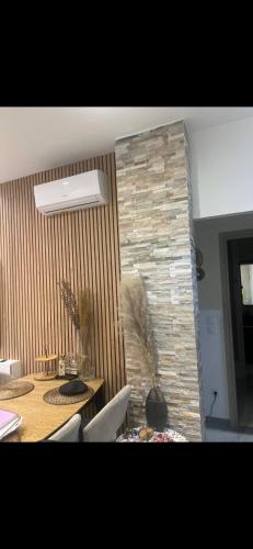 une salle à manger avec une table et un mur en pierre dans l'établissement 3 Pièces de Haut Standing Nice, à Nice