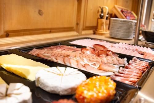 a buffet with many different types of meats and cheese at Hotel Garni Waldschlössl in Ischgl