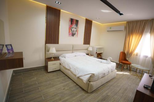a bedroom with a large white bed and a desk at Pyramids Sunshine View in Cairo