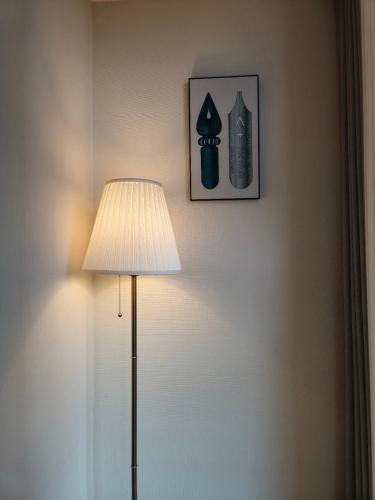 a lamp in a room with a picture on the wall at Mango&Haru House in Seoul