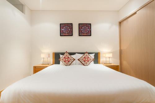 a bedroom with a large white bed with two pillows at Ocean Apartment Two Bedrooms in Danang