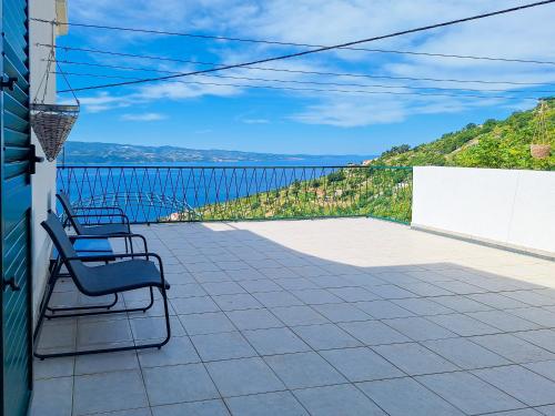 a balcony with two chairs and a view of the water at House Rinomeri in Lokva Rogoznica