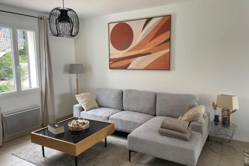 un salon avec un canapé et une table dans l'établissement Villa Lisa - piscine chauffée, à LʼIsle-sur-la-Sorgue