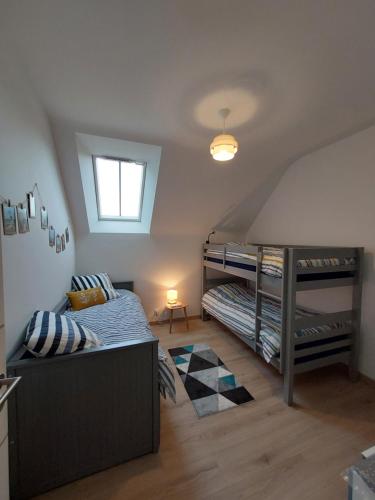 une chambre avec deux lits superposés et une fenêtre dans l'établissement Menhirs et plages Carnac, à Carnac