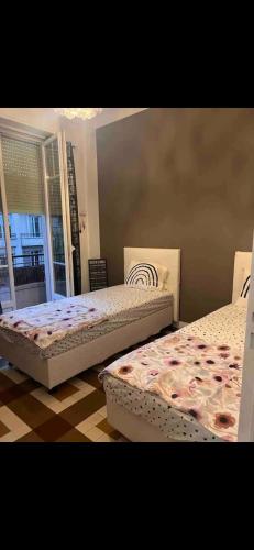 deux lits assis dans une pièce avec une fenêtre dans l'établissement appartement 10mn à pied plage promenade, à Nice