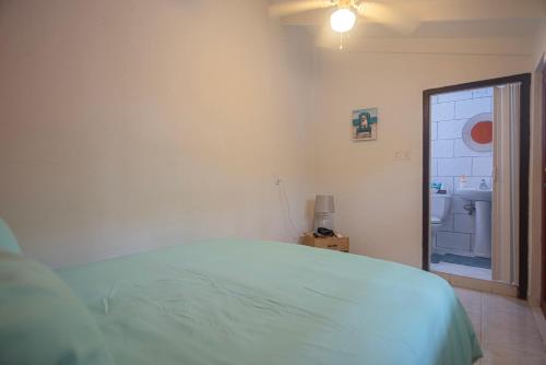 a white bedroom with a bed and a window at Casa Trankilo in Paradera