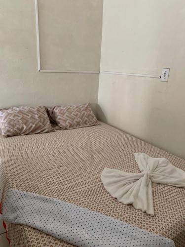 a bed with a bow on it in a room at Hospedagem in Barreirinhas