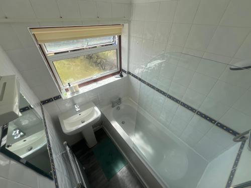 a bathroom with a sink and a toilet and a shower at 3-Bed House - Sleeps 5 with free on street parking in Leighton Buzzard