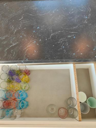 a drawer with a bunch of glass items in it at Ferienwohnung Dorfleben, nahe Jennersdorf und Therme in Windisch Minihof