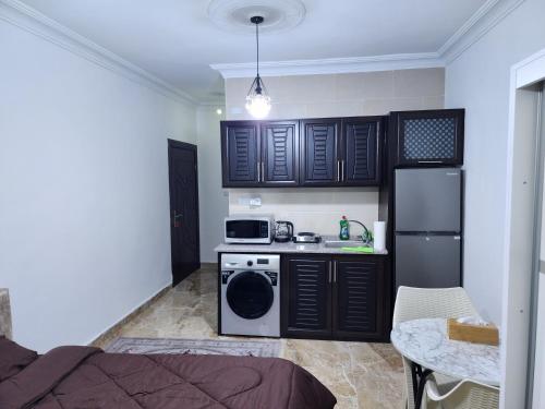 una piccola cucina con mobili neri e una stufa di Salo StudioS ad Amman