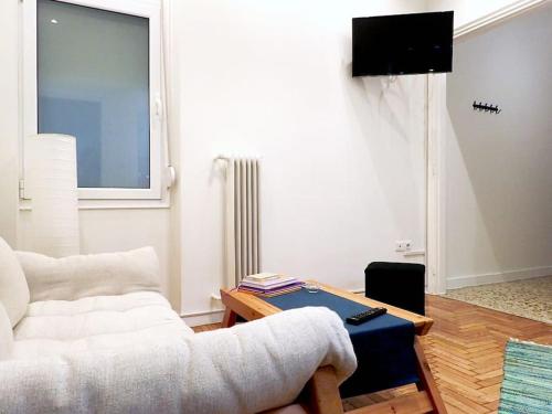 a living room with a white couch and a table at Athens Pangrati cute apt, 15 mins from metro in Athens