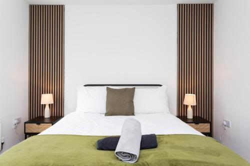 a bedroom with a large white bed with two lamps at Lancers Close House in Leyland