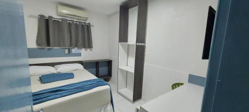 a small bedroom with a bed and a window at hostel Araçoiaba in Araçoiaba